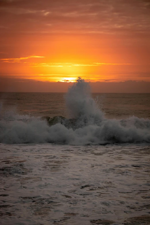 the sun is setting over a calm ocean