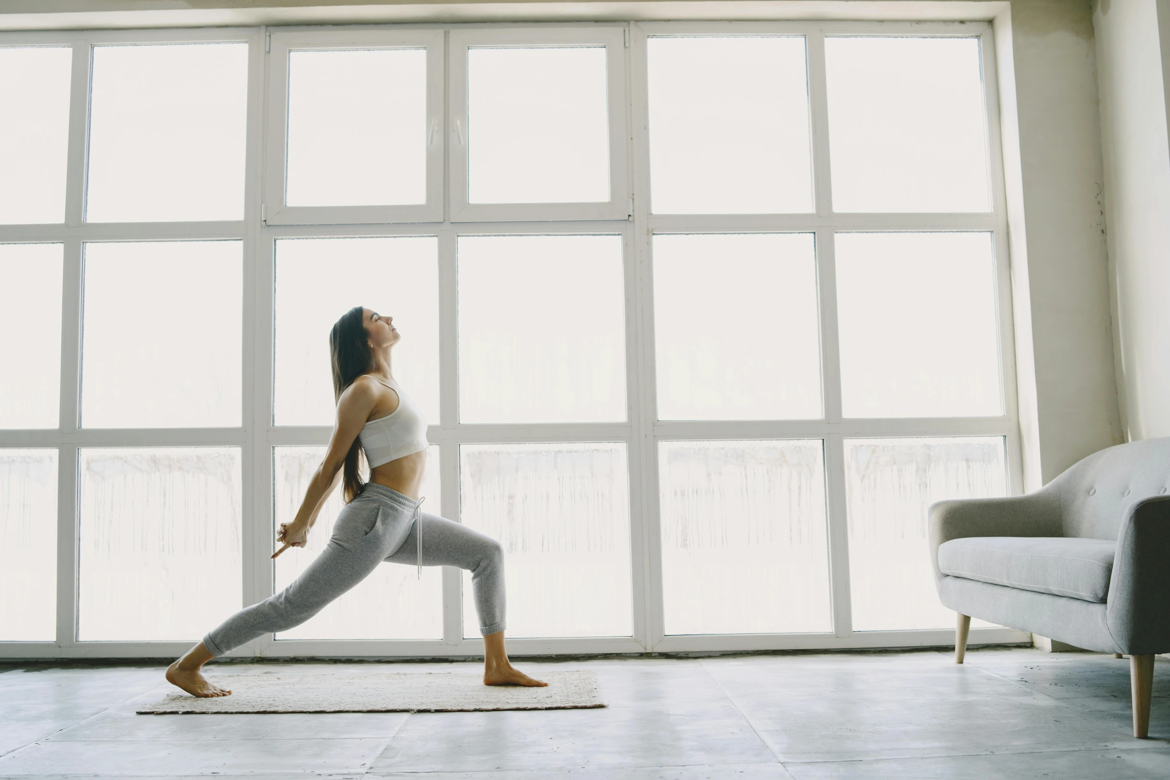 woman doing yoga in front of a window