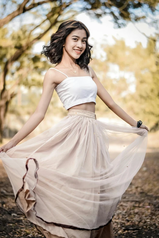 a girl poses in a white dress in an open field