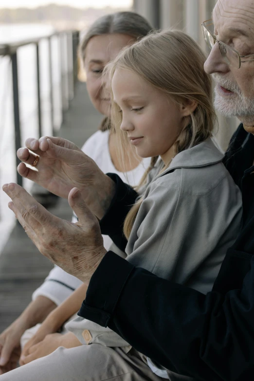 an elderly man with glasses and a  hold their hands together