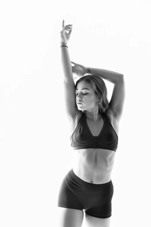 black and white pograph of woman in sports  with hands up