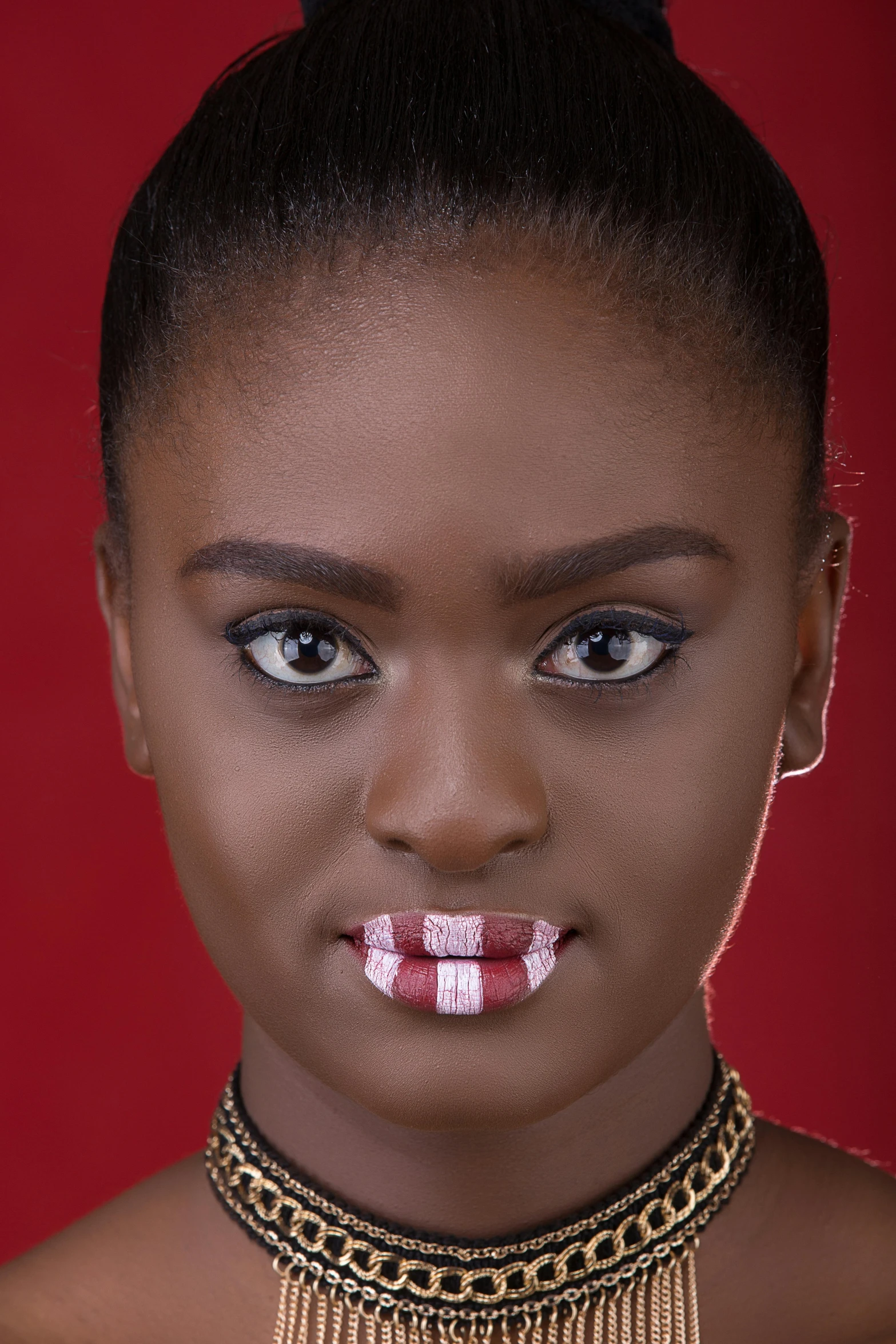 a woman in red is wearing a black and gold necklace