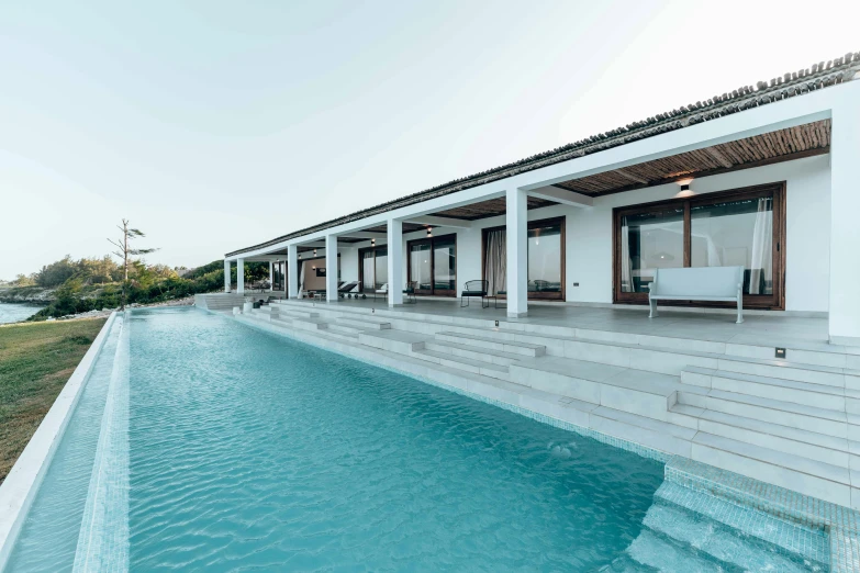 a modern house is pictured at the edge of the swimming pool