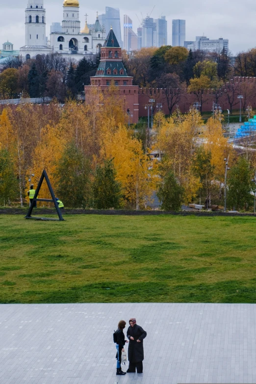 a man and a woman are standing in a park