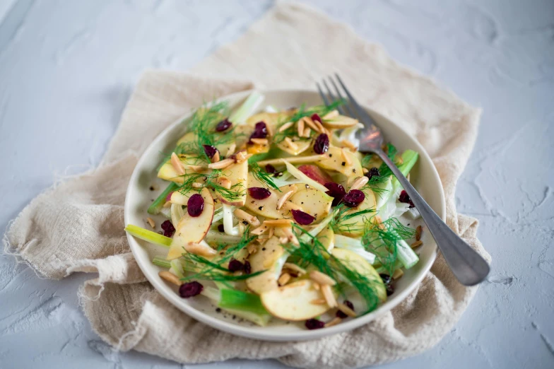 a bowl full of apples, celery, and red onion