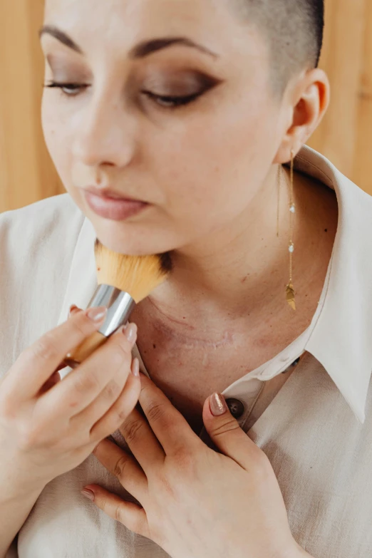 a woman brushing her face with a brush