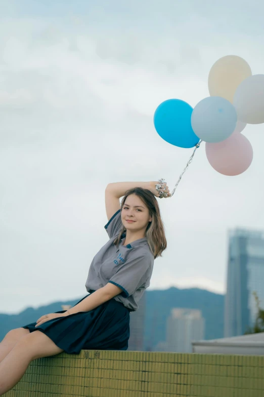 an attractive woman holding balloons behind her head