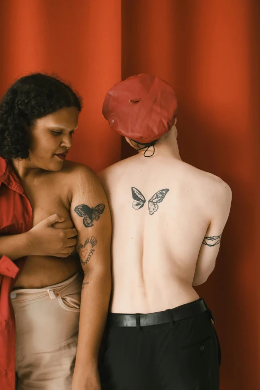 two females with erfly tattoos standing back to back