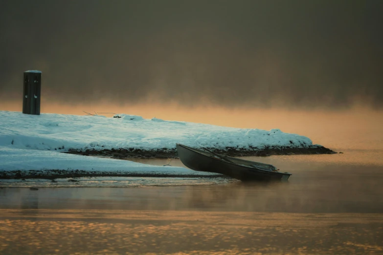 a lone boat is resting on an icy day
