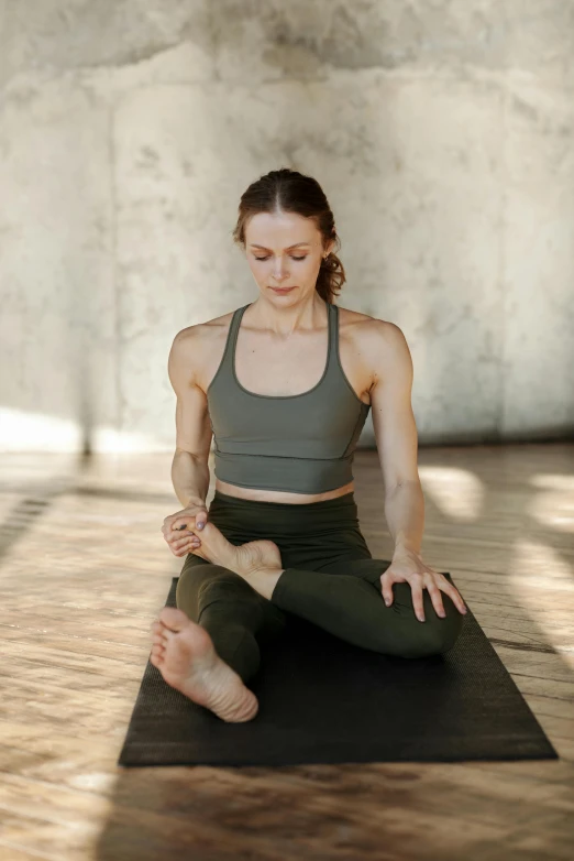 a woman practices yoga outside on a mat