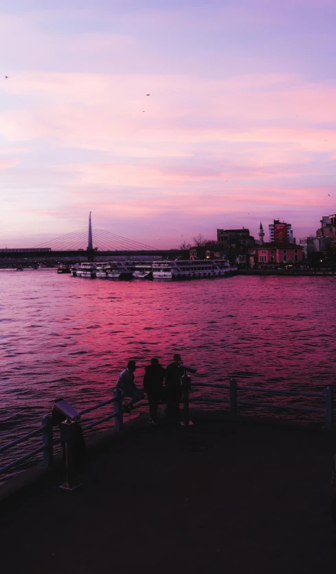 people sit on a bench near the river