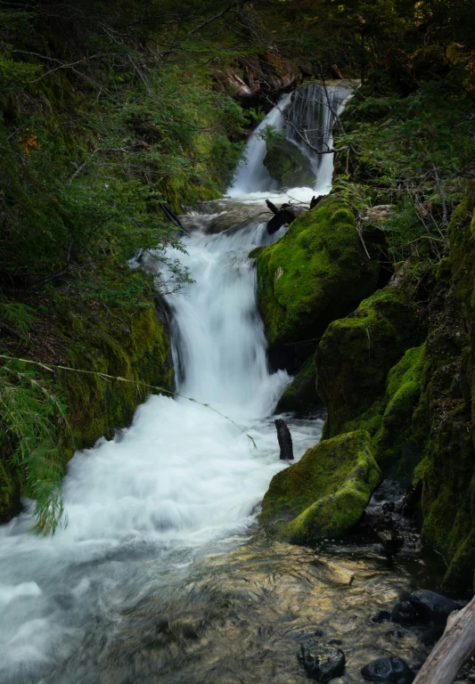 a small waterfall with some moss on it