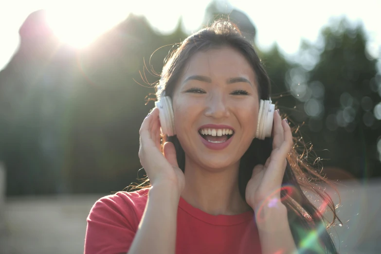 an asian girl with headphones listening to music