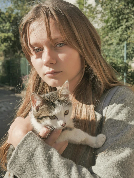 the girl is holding her cat outside