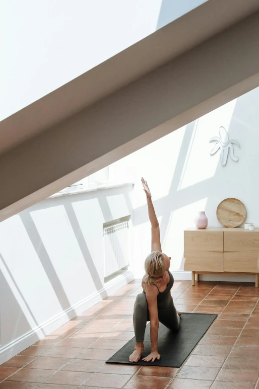 a woman doing yoga sitting on top of a mat