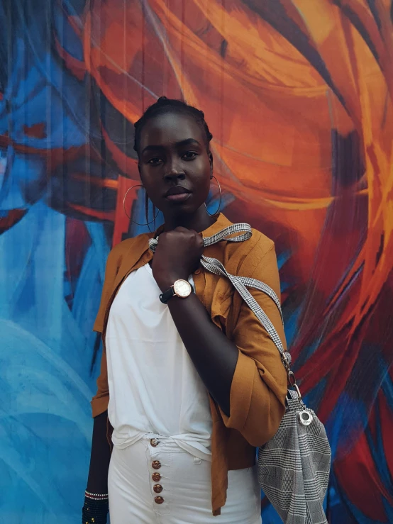 a black woman is standing by a colorful background