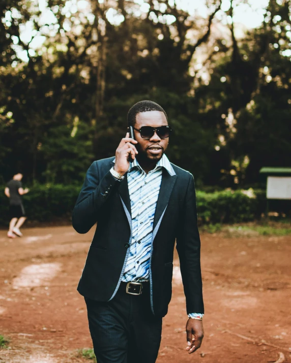 an african american man in a business suit talking on the cell phone