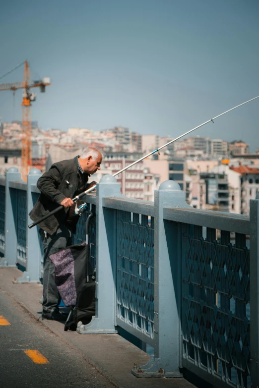 a man on top of the bridge with fishing rods