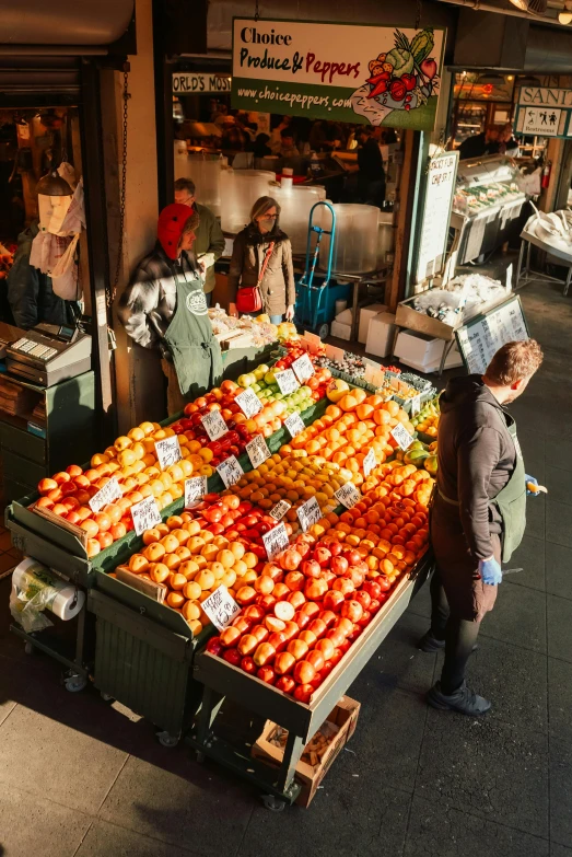 people at a fruit and vegetable market buying apples