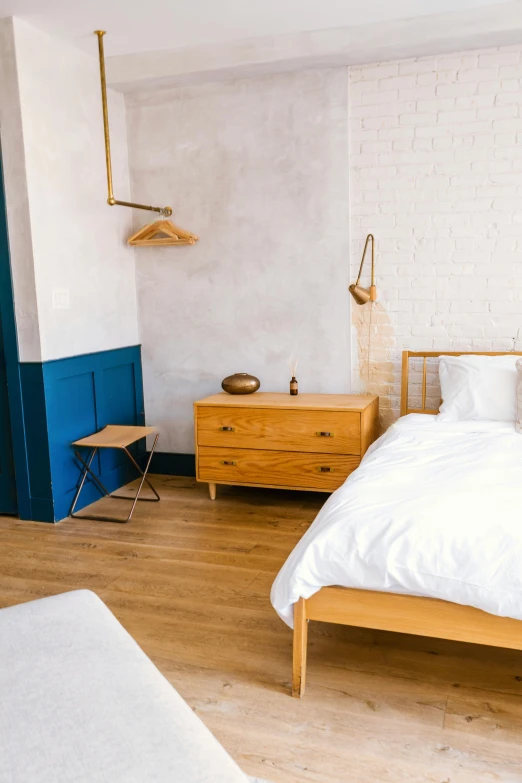 a bedroom with blue accent walls, bed and chest