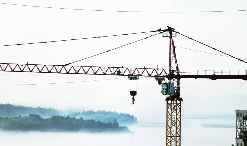 large crane on construction site with fog in background