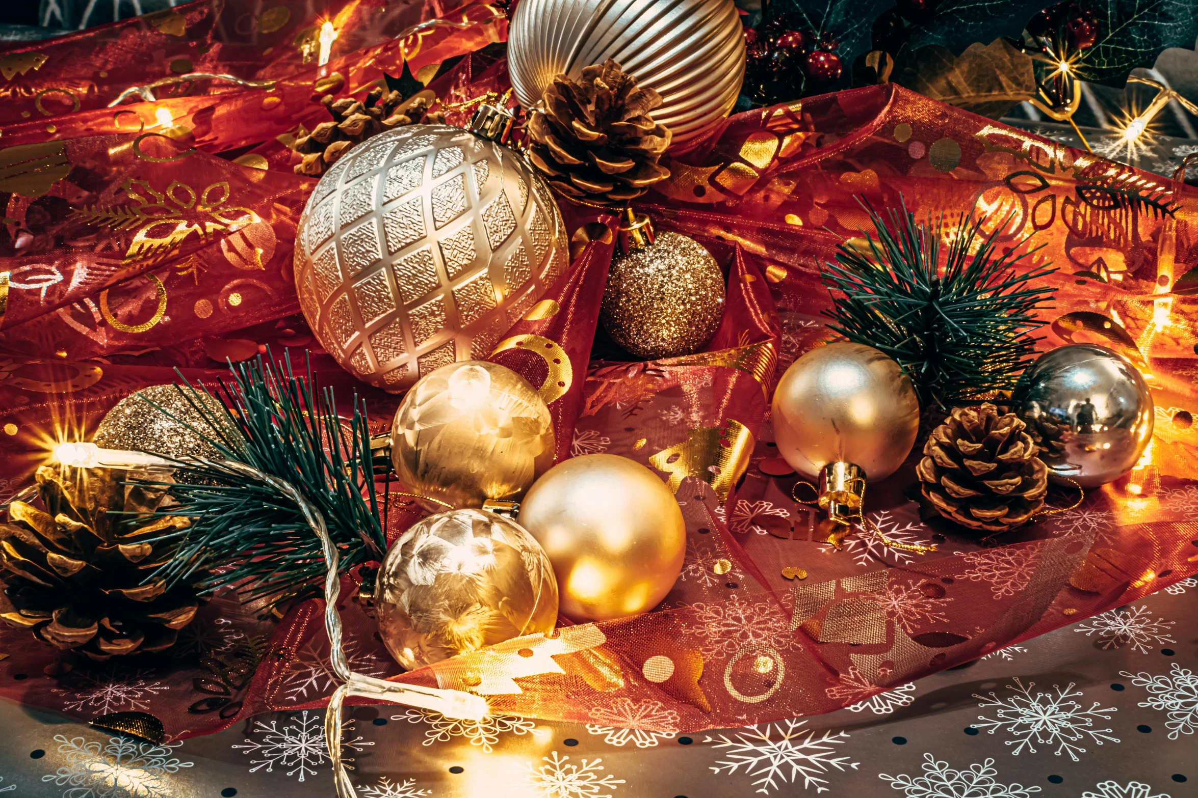 a large group of golden and white ornaments on a red table cloth