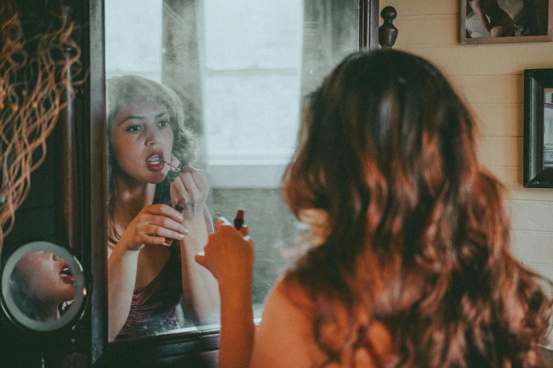 woman brushes her teeth in front of a mirror