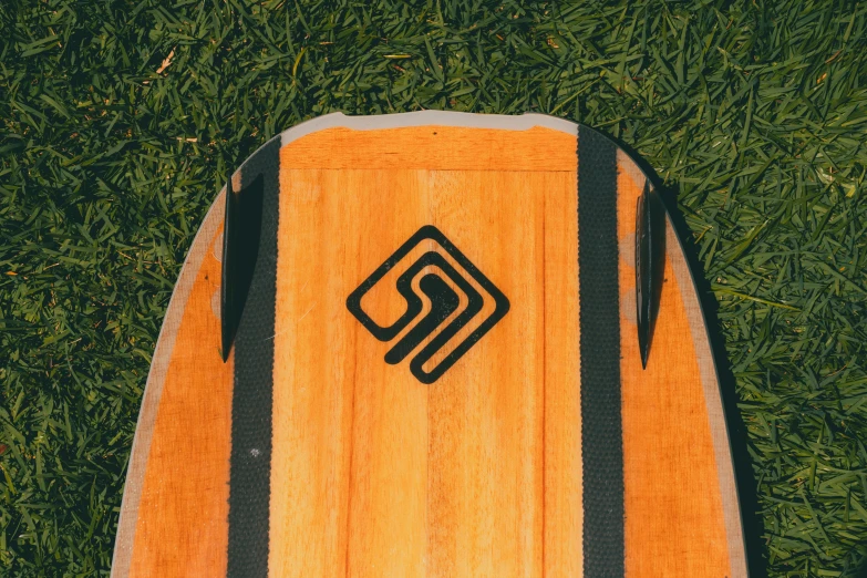 a surf board sitting in the grass near some green grass