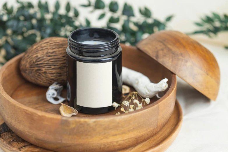 a small jar with a white label is sitting on a wooden platter