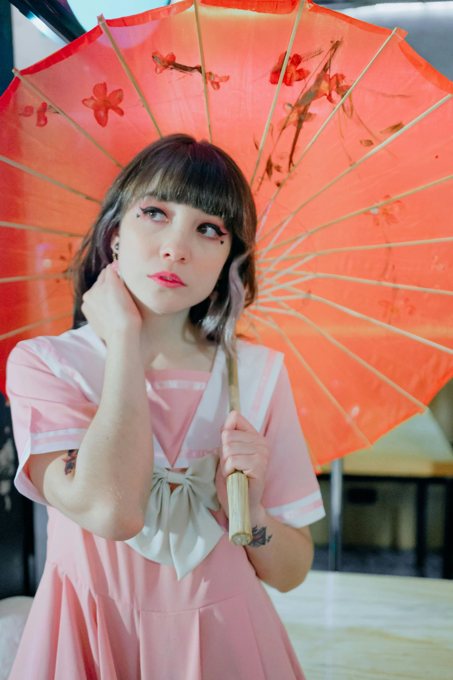 a girl in pink dress holding a orange umbrella