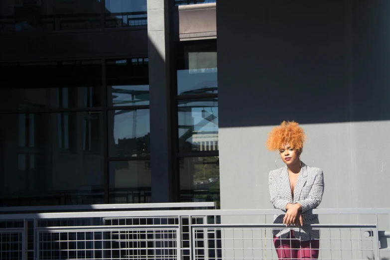 an orange hair woman standing on a metal railing