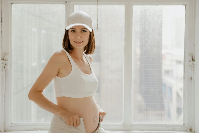 a pregnant woman standing in front of the window