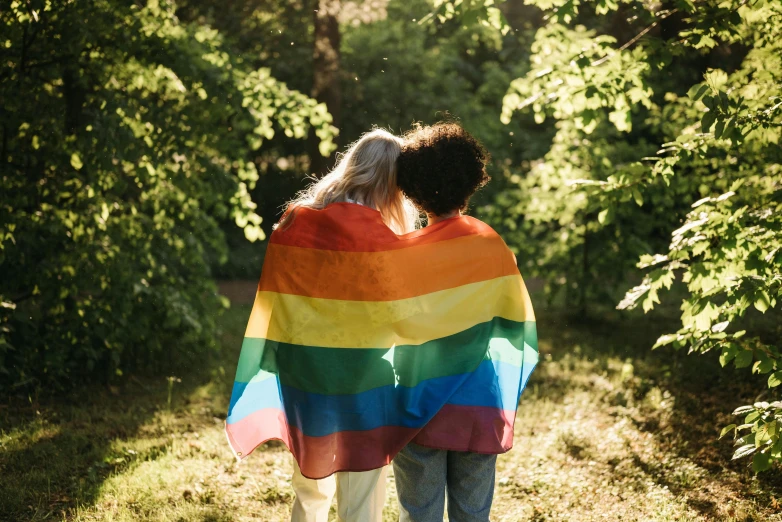 two people wrapped up in a multi colored blanket