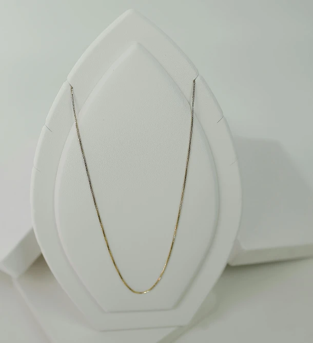 some sort of necklace is displayed on a white table