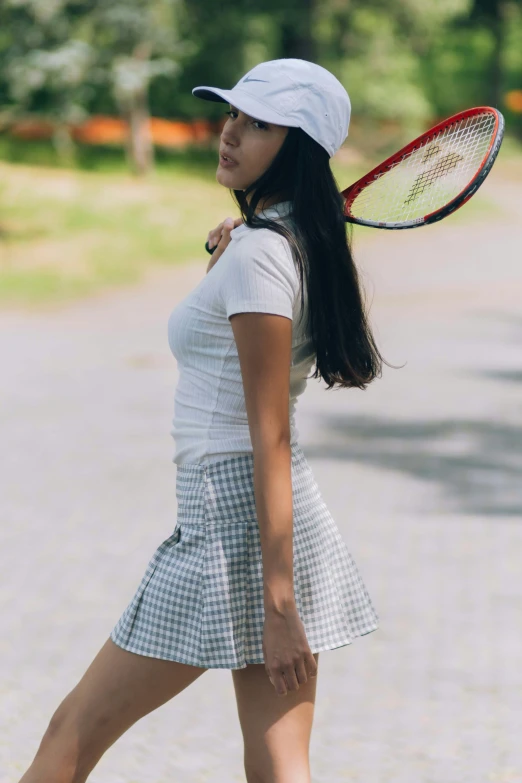 the girl in the white dress has a tennis racket