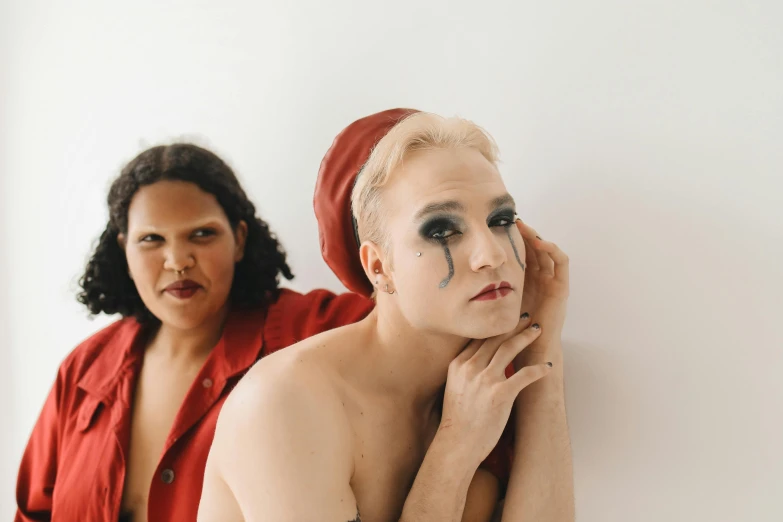 two women that are standing up wearing makeup