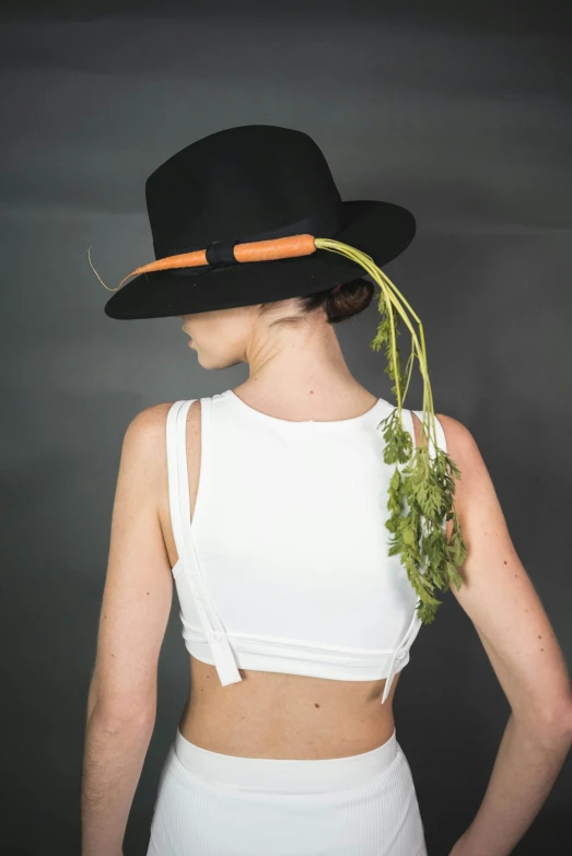 a woman with vegetables on her head wearing a top