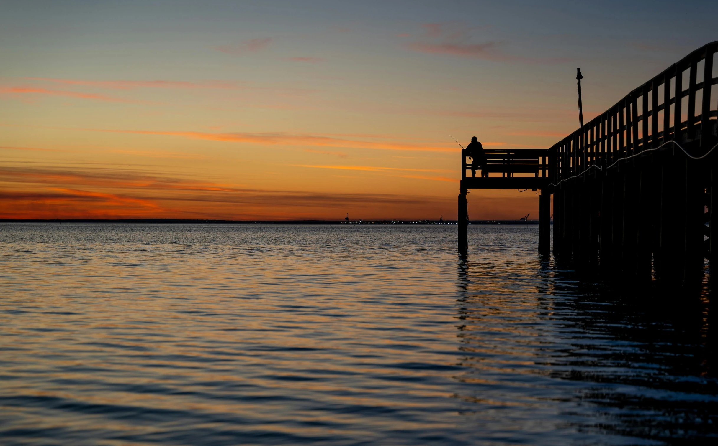 a boat at the end of a dock during sunset