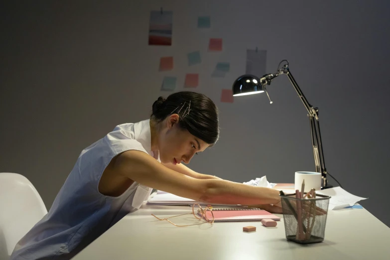 a woman with her arm up on a table in front of a lamp