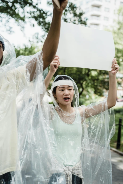 a group of people wearing plastic standing in the street