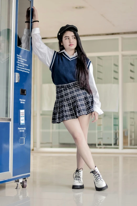 a woman in school uniform standing by an old machine