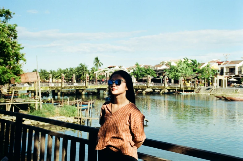 a woman standing on a deck near a river