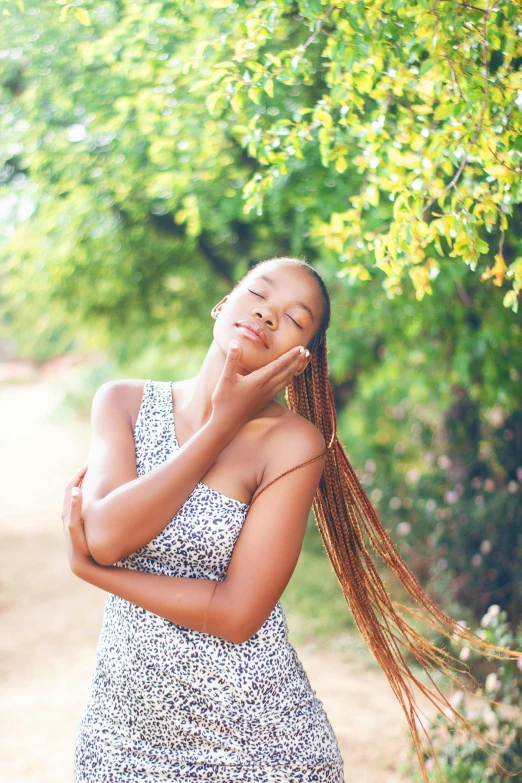 a young woman leaning on a tree in a dress