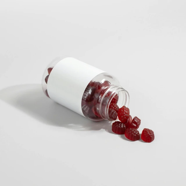 several jelly candies spilling out of a white pill bottle