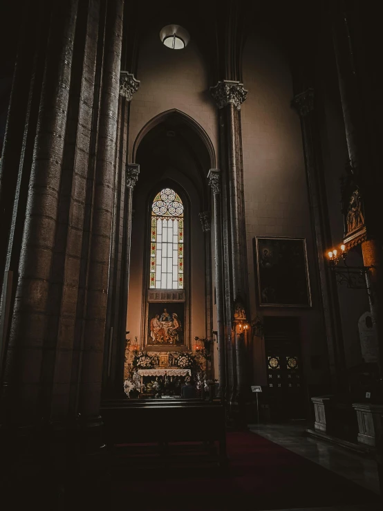 a very tall, elegant looking church with an alter and stained glass windows