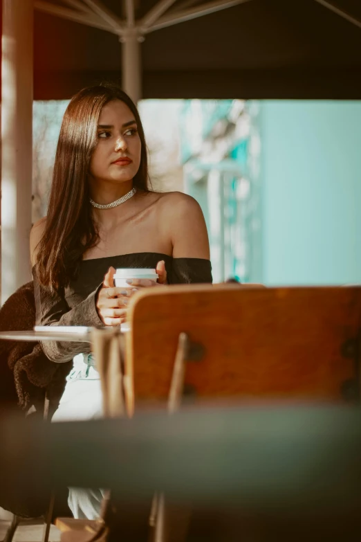 a young woman with long hair standing in front of a table