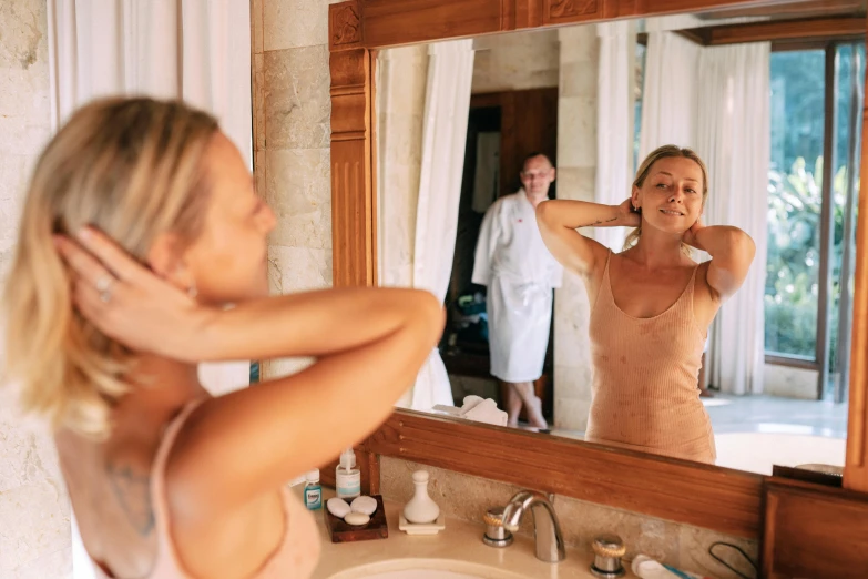 a woman brushing her hair in front of a mirror