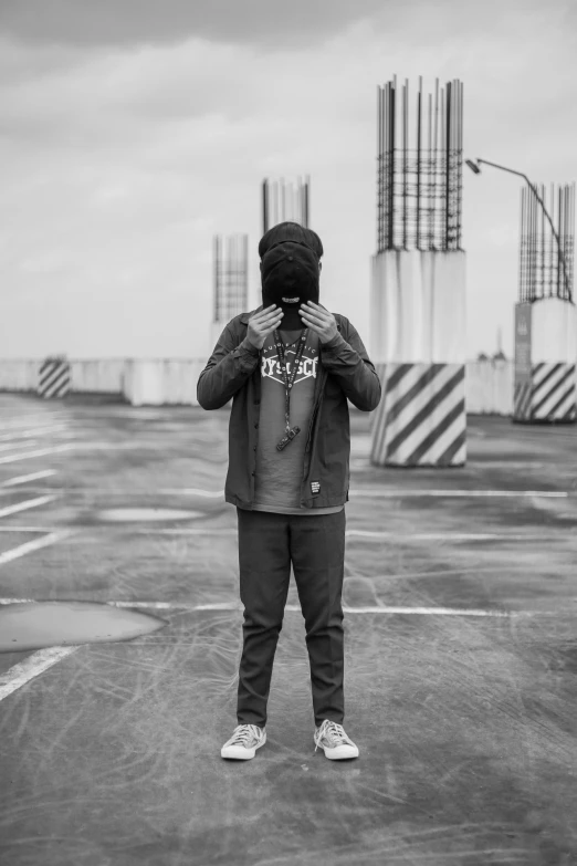 a man in hoodie on parking lot looking out