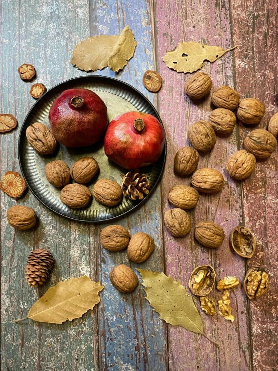 a plate with several types of nuts and apples