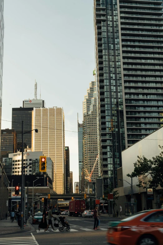 cars and pedestrians traveling down the street in front of tall buildings